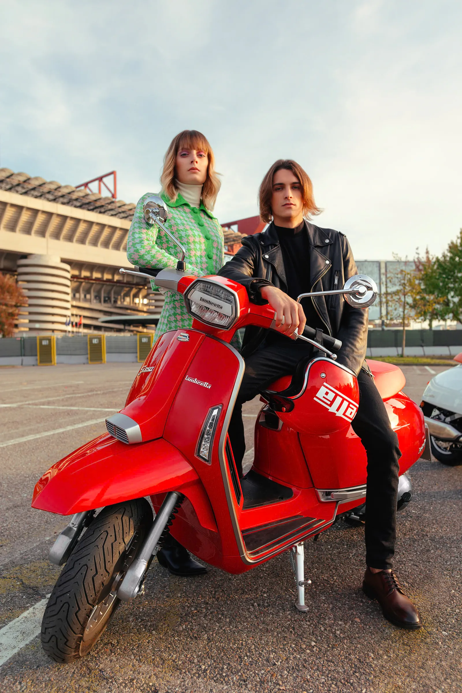Cặp đôi bên Lambretta G350 màu đỏ trước sân vận động